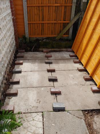 Bricks laid out in line with the support slats of the shed base