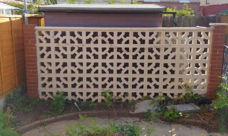 View of the shed behind a decorative wall