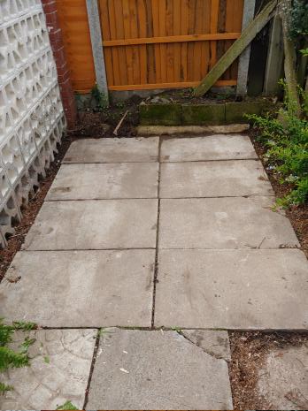 A small area of paving surrounded on three sides by fencing and a decorative wall